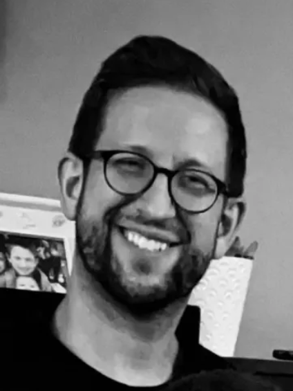 Tim Moench smiling in a black and white portrait